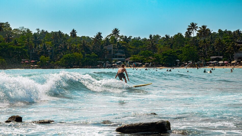 a surfer riding a wave at Hiriketiya at a cheap surf camps Sri Lanka