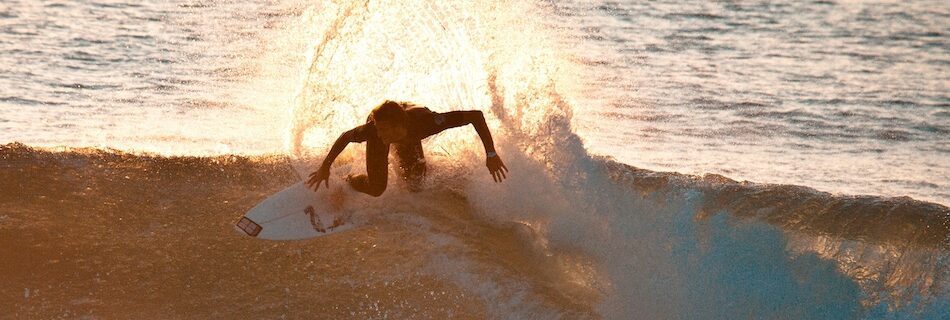 a surfer doing a backside turn on a wave at a surf camp Morocco Essaouira