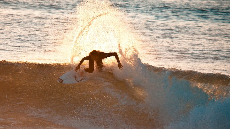 a surfer doing a backside turn on a wave at a surf camp Morocco Essaouira