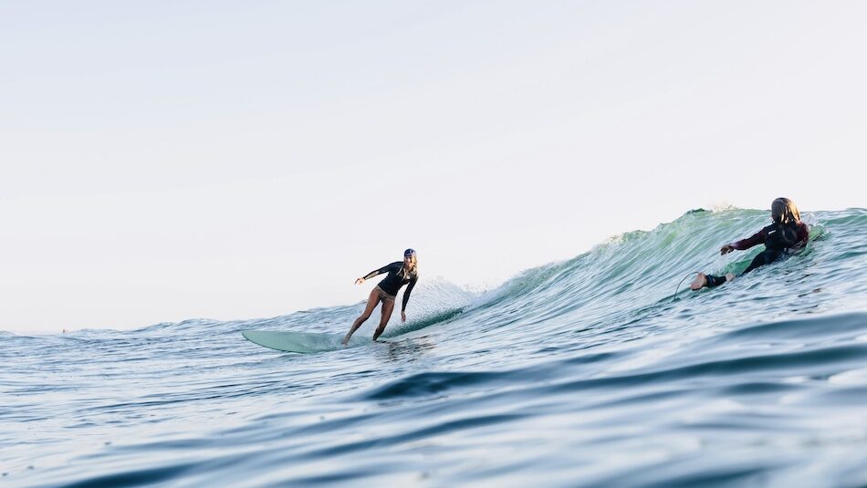 a girl surfing on a wave at a surf camp Portugal beginner
