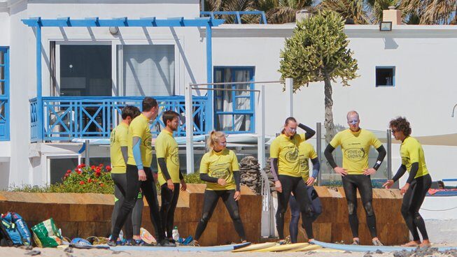 surfers listening to an instructor at Homegrown surf camp