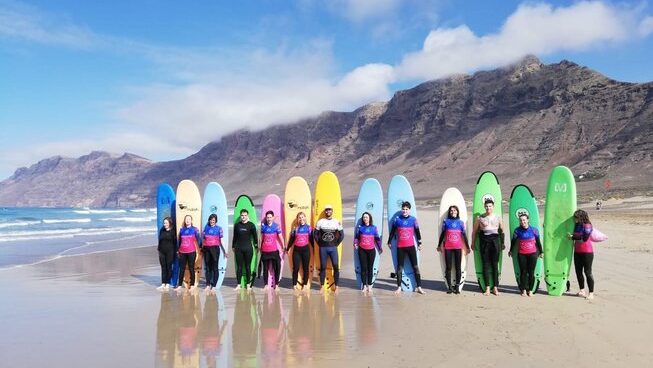 surfers standing with their surfboards in a line at Lanzarote with Lanzasurf surf camp