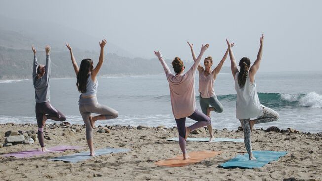 People doing yoga on the beach with Lanzasurf surf camp