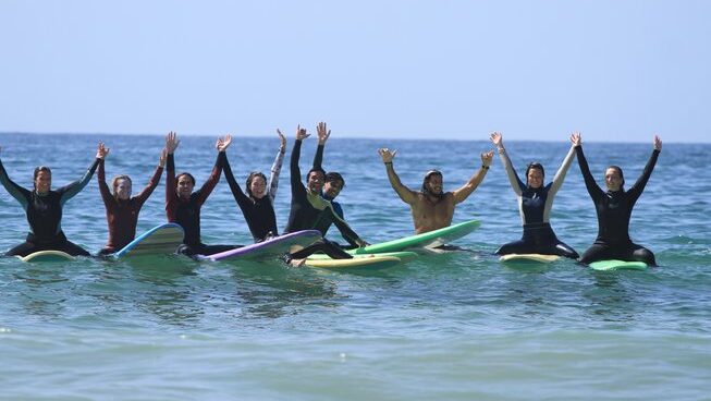 Surfers in the water with hands in the air at Moana Surf Maroc surf camp