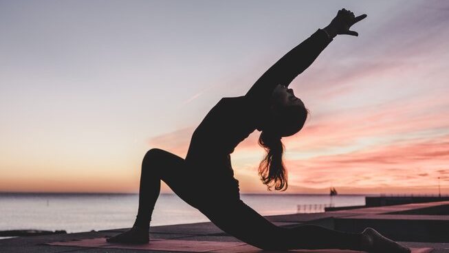 a person in a yoga pose at sunset at Sand Surf Morocco surf camp