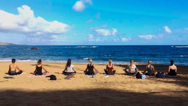 people doing yoga on the beach with See Yoga Holidays