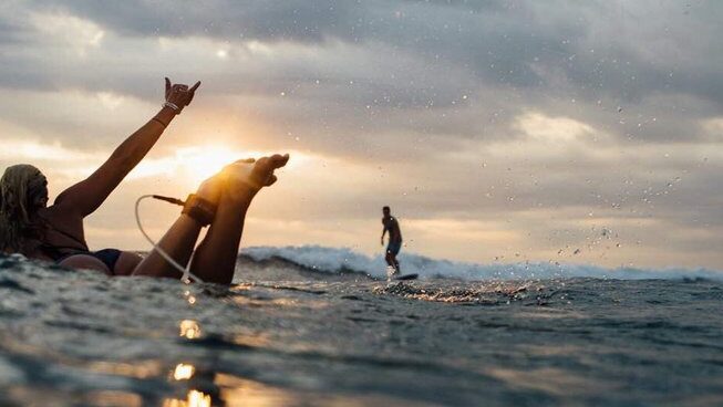 a surfer on a wave with a person watching at Solid Surf and Yoga House Sri Lanka surf camp in Weligama