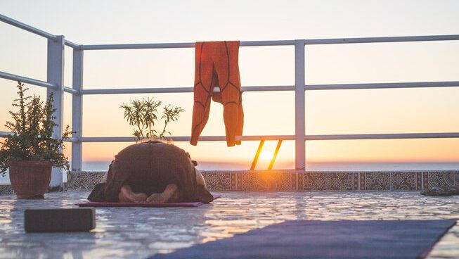 a person doing yoga at sunset at Surf Coast Morocco surf camp
