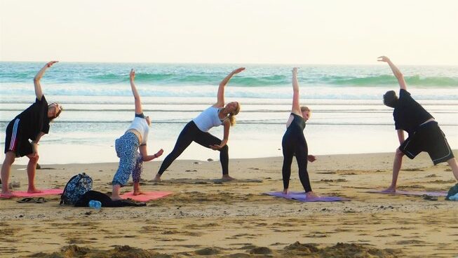 People doing yoga on the beach at Surf Paradise Morocco surf camp