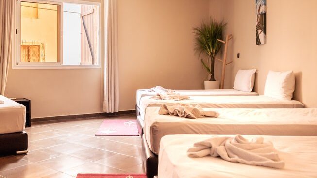Accommodation showing three single beds and window at The Surf Hotel Morocco surf camp
