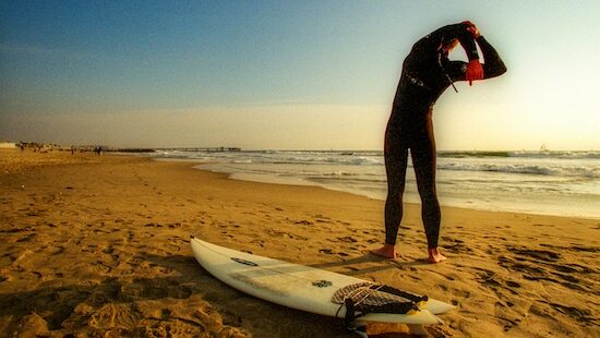 A surfer stretching before going out in the surf