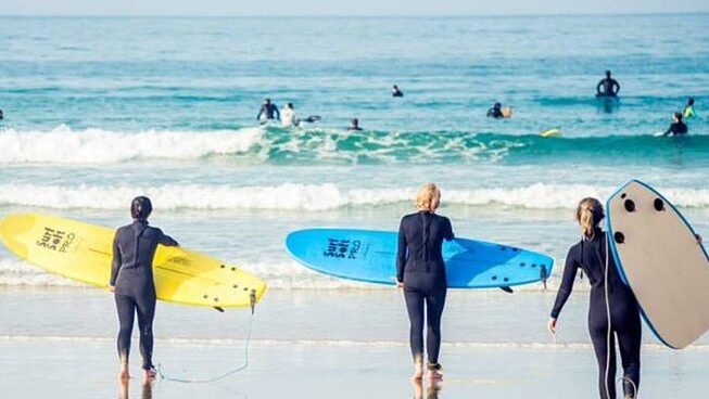 Surfers learning how to surf with Alex surf school