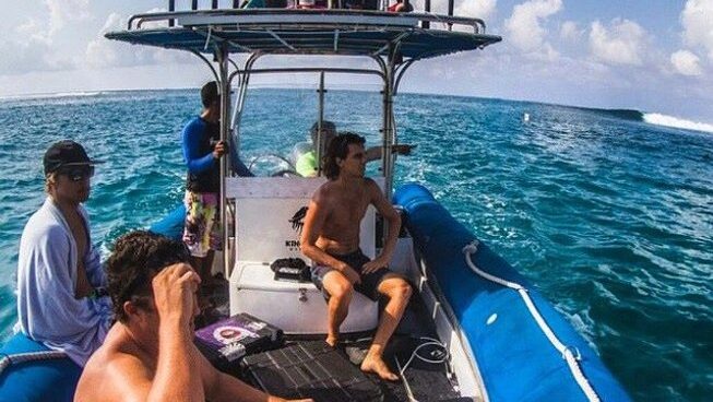 Surfers on a boat looking at waves with Kingfisher Mentawai surf camp