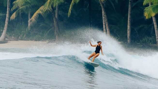 a girl surfer doing a turn at Mentawai