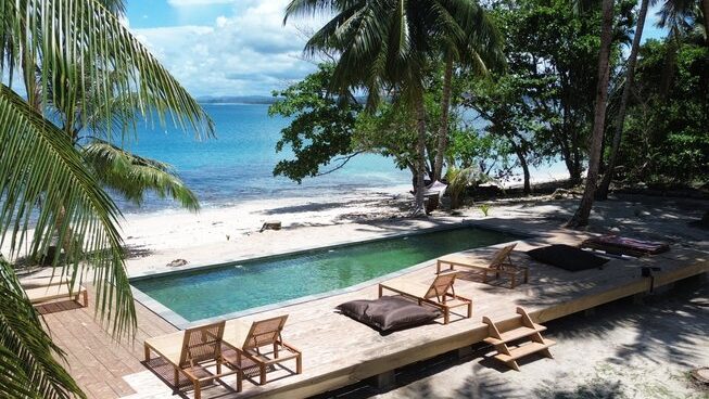 Accomodation and pool with chairs at VAYA Mentawai