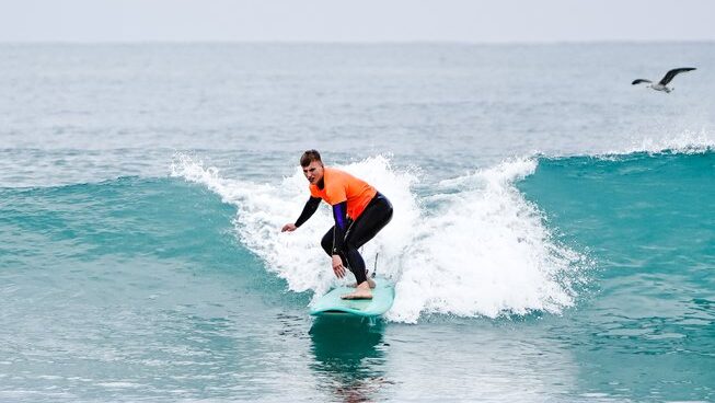 a learner surfer on a wave with 9Pies Surf School El Palmar