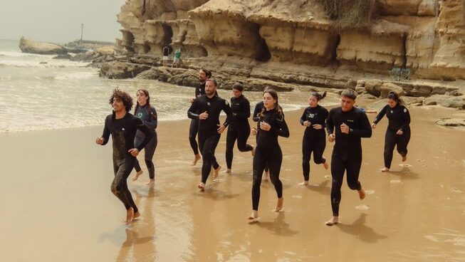 surfers getting warm on the beach before a surf with Anamar Surf Morocco