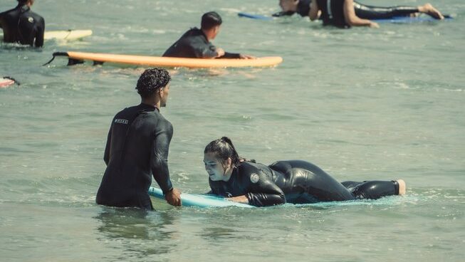 A surfer learning how to surf with instructor with Anamar Surf Morocco