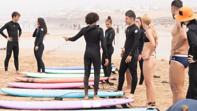 leaner surfers on the beach with surfboards
