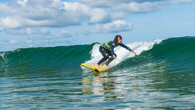 A learner surfer on a wave with Latas Surf surf camp