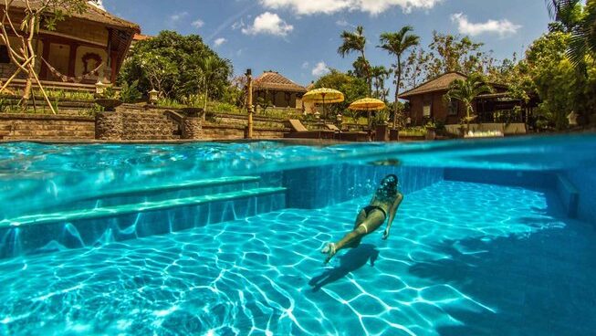 A person swimming in a pool at Mondo Surf & Lifestyle Village