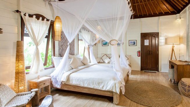 double bed and mosquito netting at Mondo Surf & Lifestyle Village