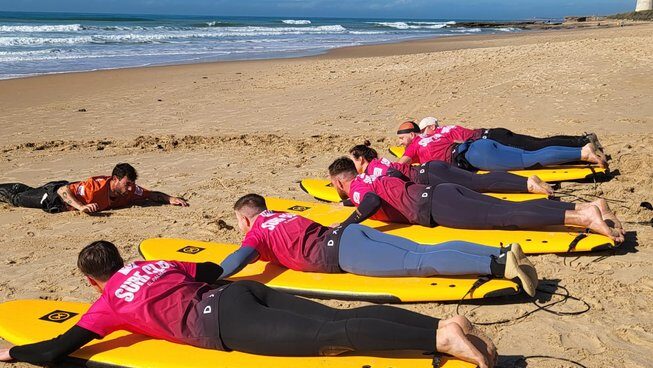 surfers learning on the beach with Surf Club El Palmar