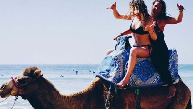 Two girls on a camel with Surf Soul Adventure surf camp