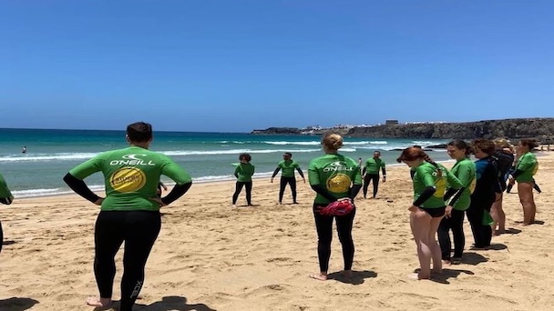 surfers on the beach enjoying learning about their Fuerteventura surf holiday