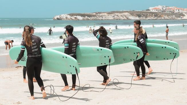 people learning how to surf with surfboards at The Salty Peniche surf camp