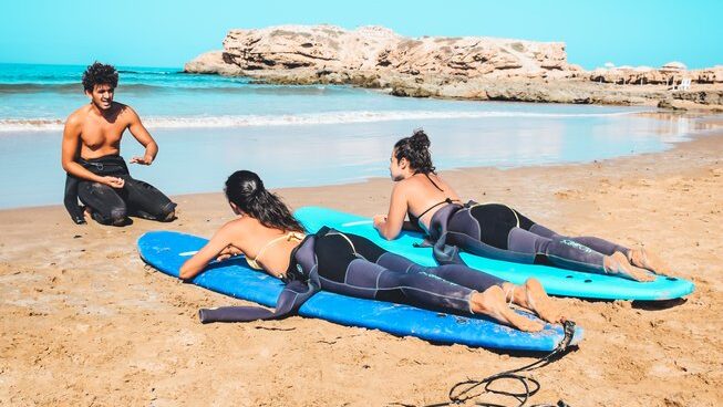 two surfers learning how to surf with an instructor with Tiziri Surf Maroc