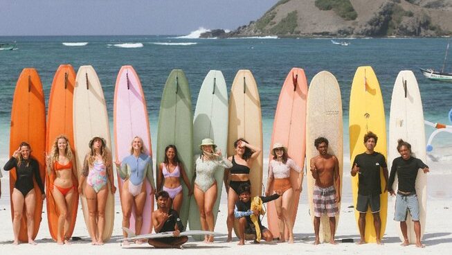 people standing on the beach with surfboards at an Indonesia surf camp