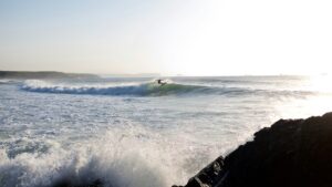 a surfer doing a turn on a wave during his time at the best surf camps in Spain