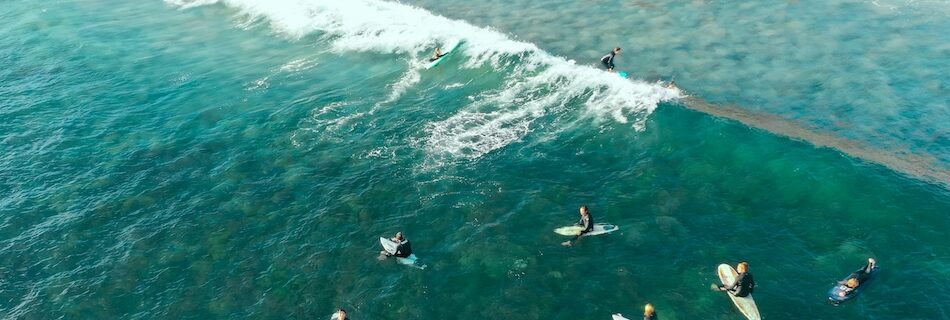 Surfers in the water waiting for a wave during an Affordable Surf Hostel Peniche