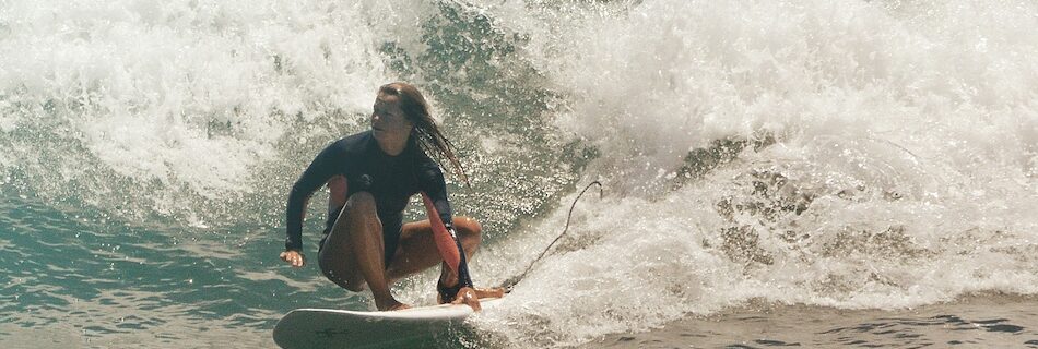 A surfer holding the rail on a wave while at an Taghazout Surf Camp and Yoga Retreat