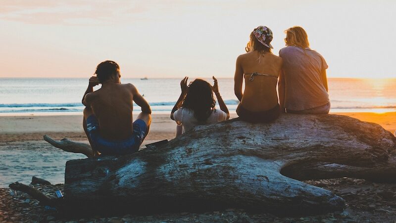 Travellers sitting around a fire on a Moroccan beach, sharing stories and enjoying why surf camps in Morocco are safe and welcoming