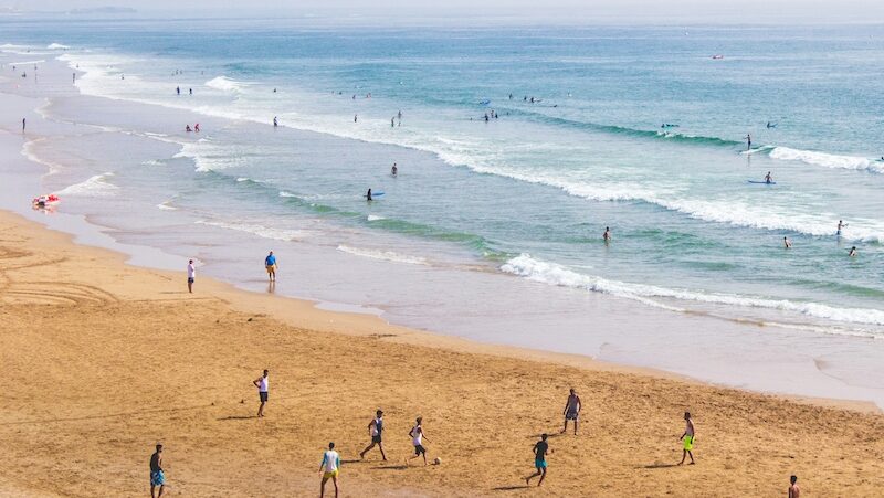 People playing soccer on the beach in Morocco showing why surf camps in Morocco are safe