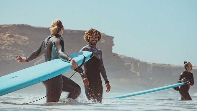 A student and instructor learning how to surf during a Taghazout surf camp and yoga retreat