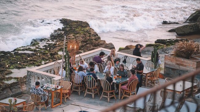 People hanging on a deck eating with ocean views during a Taghazout surf camp and yoga retreat