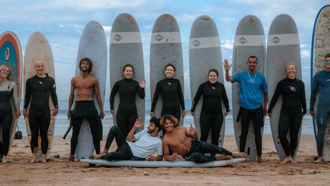learner surfers standing with their surfboards during a Taghazout surf camp and yoga retreat