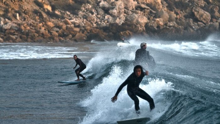 A surfer on a wave during his time at Lagos surf in Portugal