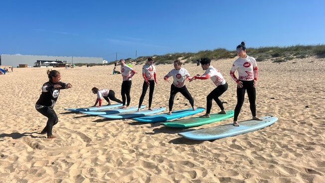 learner surfers learning on the beach at a surf hostel Peniche