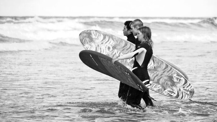 a group of surfers entering the water illustrating what is a surf camp