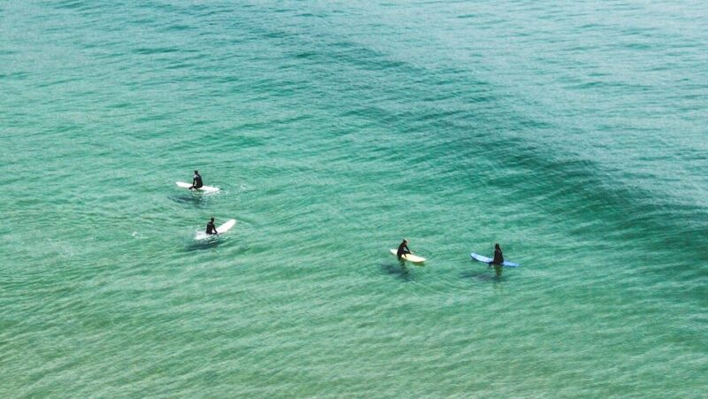 Clear blue water in Imsouane with people surfing