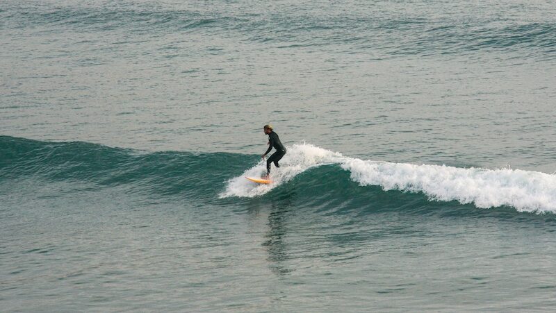 a surfer on an easy wave at imsouane and wonderSurfers in Imsouane beach and wondering Where To Surf In Morocco For Beginners