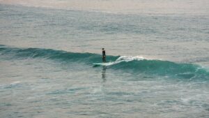 a surfer on an easy wave at imsouane and wonderSurfers in Imsouane beach and wondering Where To Surf In Morocco For Beginners