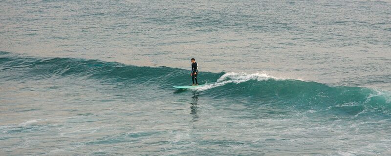a surfer on an easy wave at imsouane and wonderSurfers in Imsouane beach and wondering Where To Surf In Morocco For Beginners