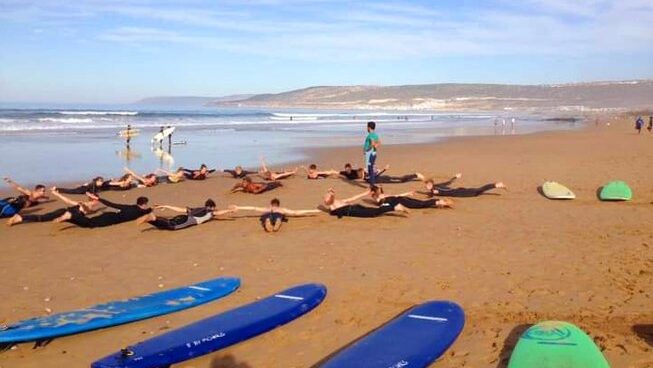 people warming up on the beach before surfing