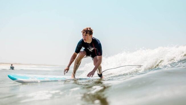 a person riding a wave on a surfboard in Tamraght