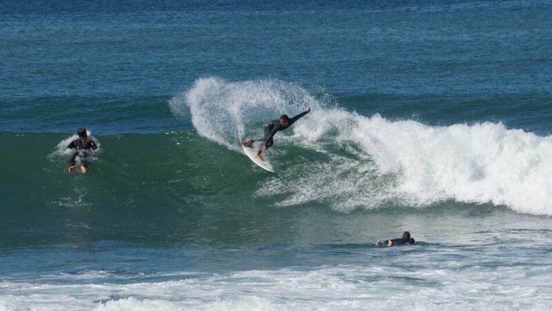 A surfer doing a big backhand turn in Ericeira Portugal